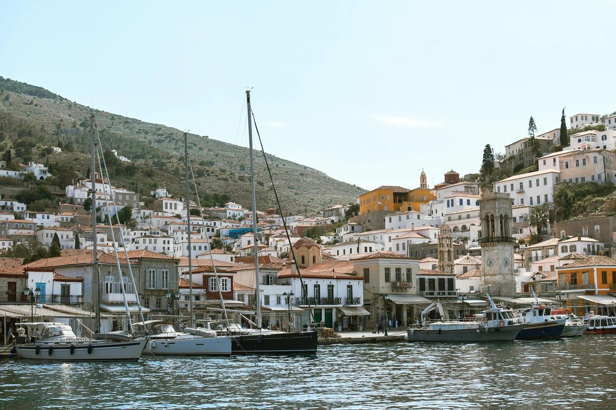 The harbor of Hydra with stone houses and boats around the water