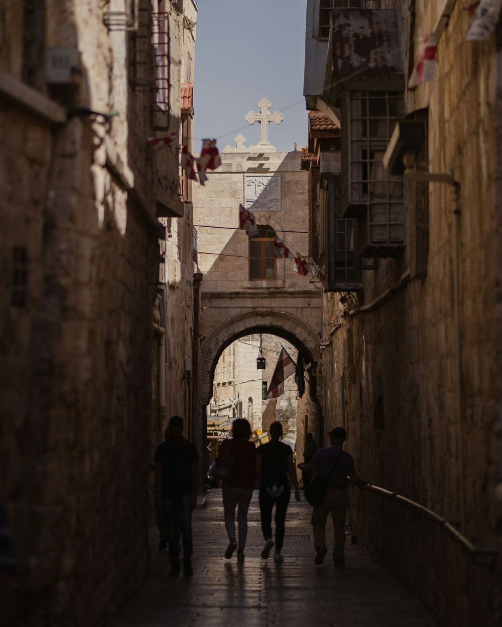 Pilgrims walking a stone lane on the Via Dolorosa in the Old City of Jerusalem