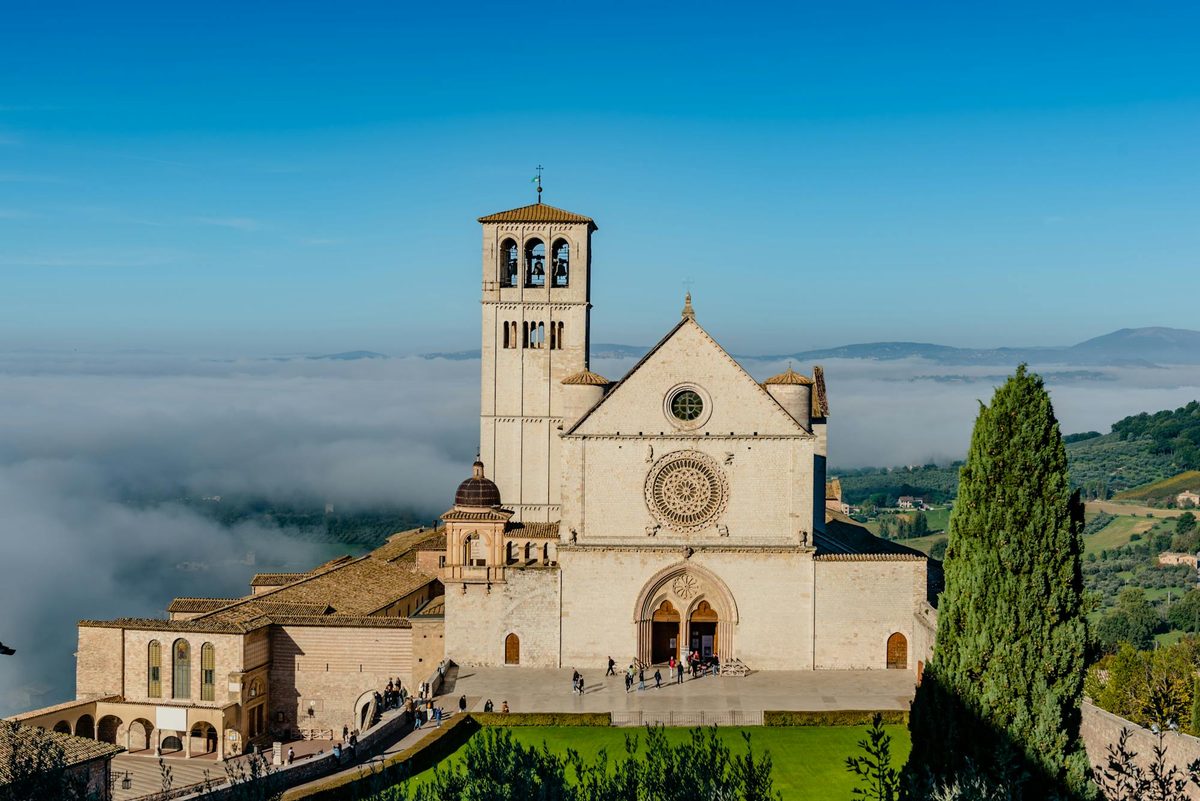 The Basilica of Saint Francis of Assisi on a green Umbrian hillside